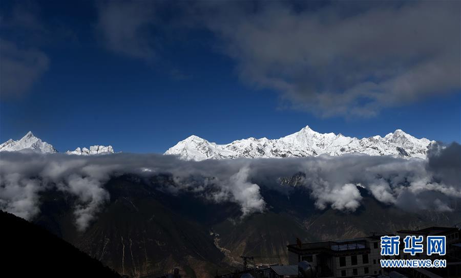 Les montagnes Meili enneigées sur les nuages