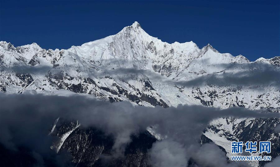 Les montagnes Meili enneigées sur les nuages