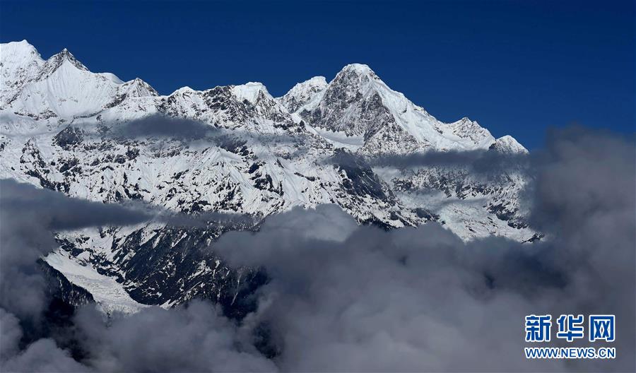 Les montagnes Meili enneigées sur les nuages