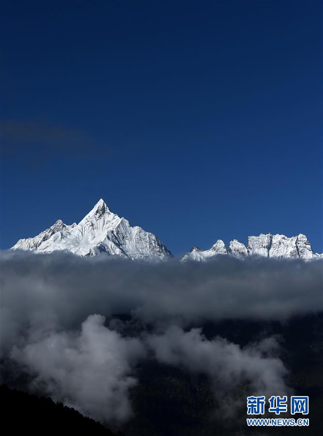 Les montagnes Meili enneigées sur les nuages